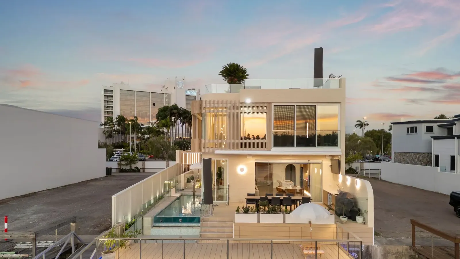 Casa La Mere at dusk seen from the water, pool terrace and living levels lit