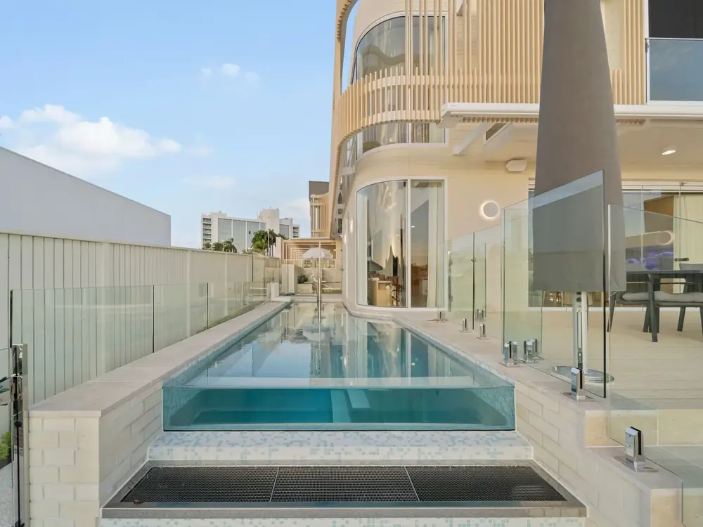 Elevated pool and entertaining terrace with glass balustrading above the water