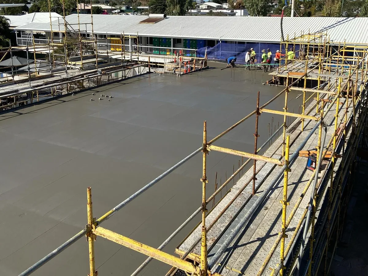 Poured and screeded commercial slab with perimeter scaffolding in place