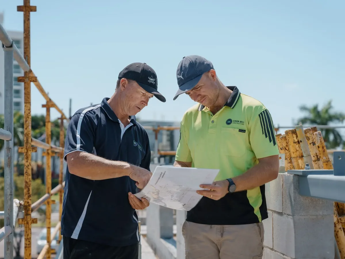 Two Simon Bell Constructions team members reviewing plans together on a commercial site