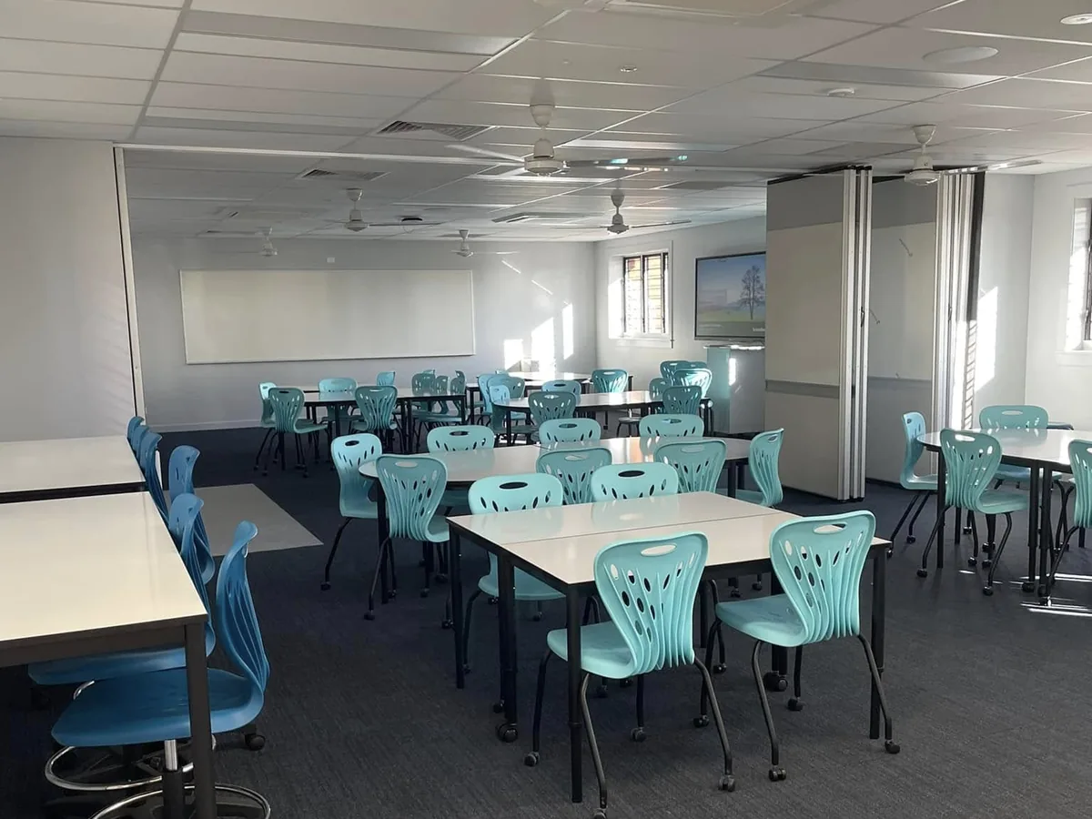 Classroom fitted out with grouped tables, task seating and full-height glazing