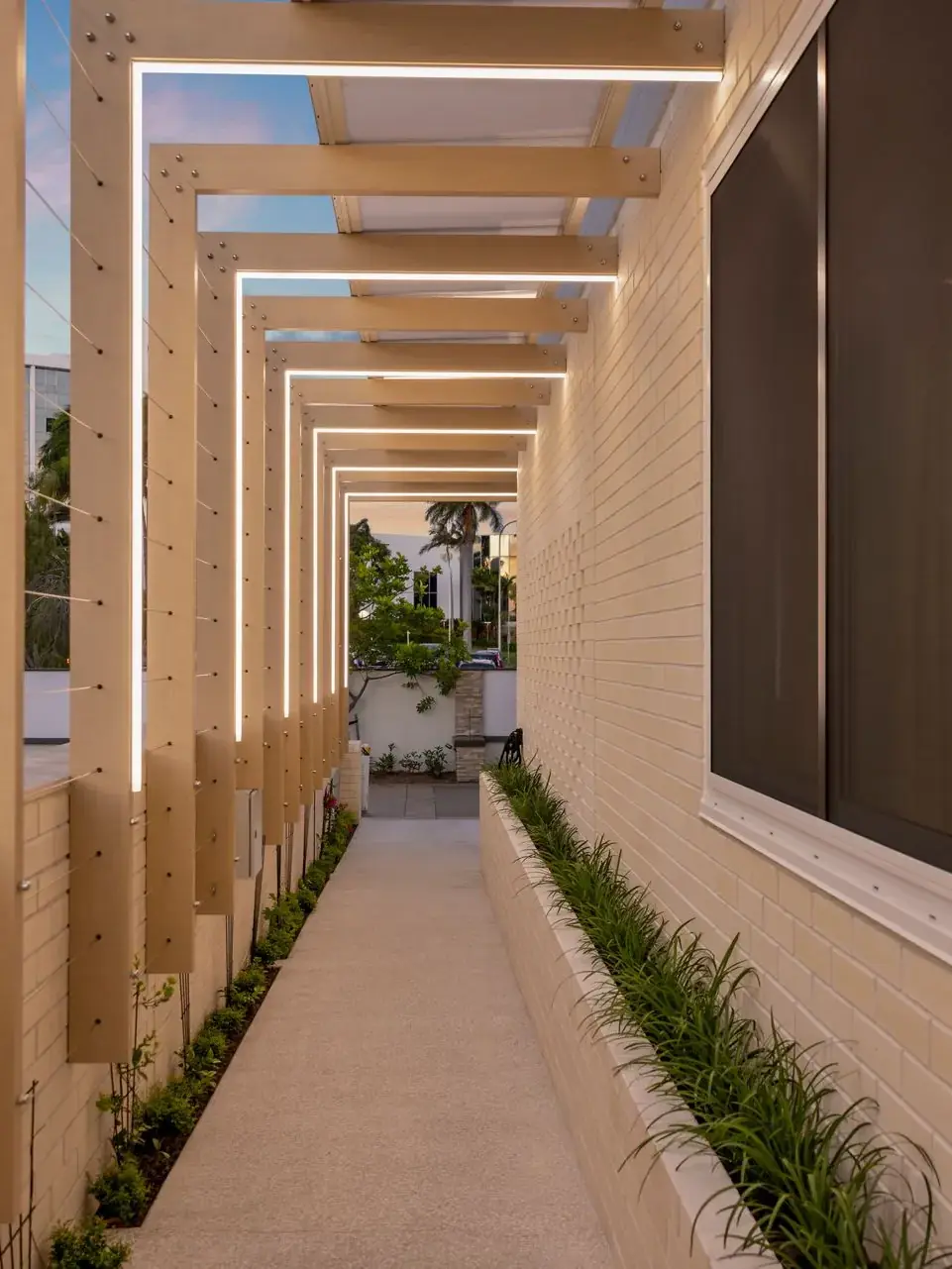Covered walkway lined with vertical timber battens running alongside a completed home