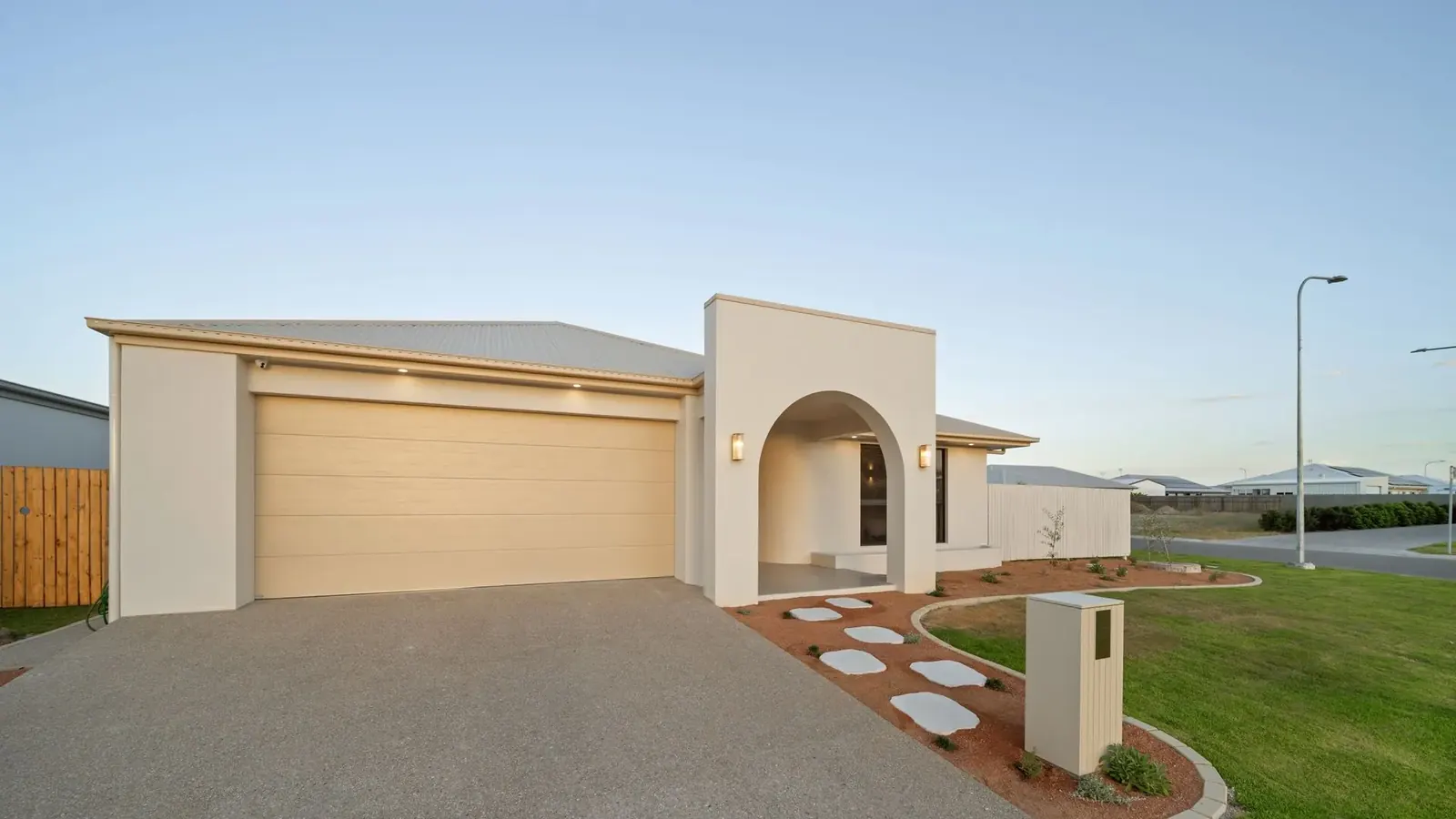 Street elevation of Sunnymount House at dusk with the arched entry lit